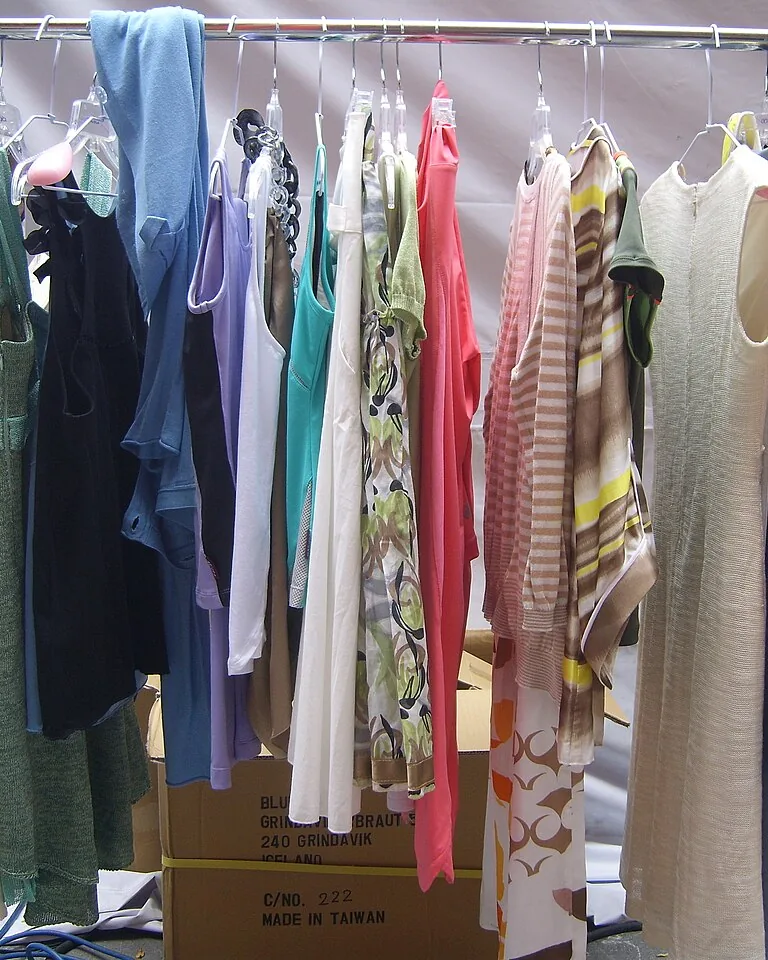 Freestanding clothing rack with shelves in a rental bedroom