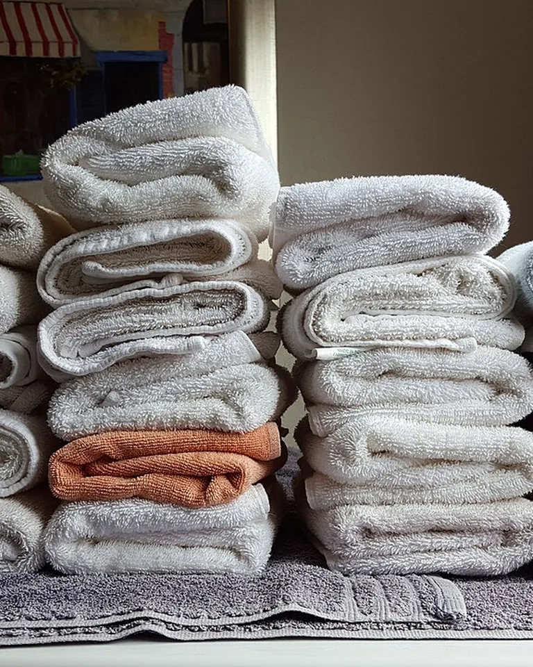 12 Stacked Laundry Room Ideas for Small Spaces That Make Every Inch Count 16 Neatly folded towels stacked on a laundry shelf