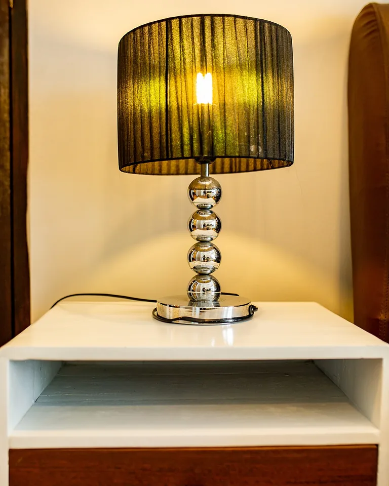 12 Married Couple Bedroom Ideas That Feel Personal and Balanced 4 Balanced bedside setup with a nightstand, glowing lamp, book, and water glass on each side