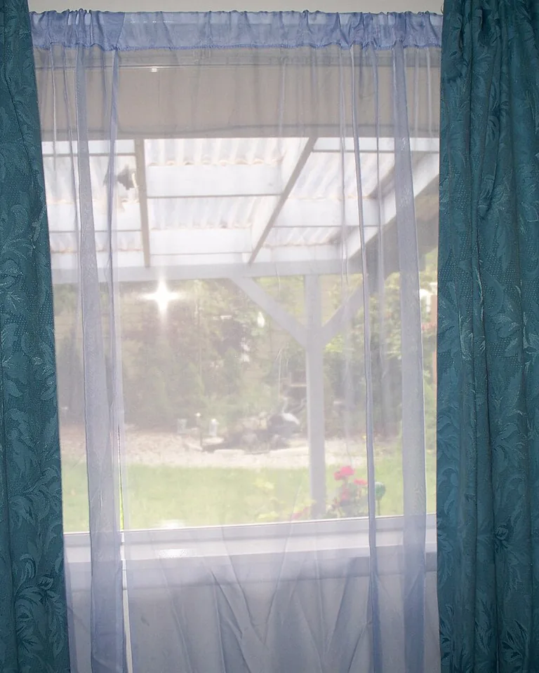 Bay Window Curtains: 11 Ideas That Make the Whole Room Feel Finished 3 Layered sheer voile panels with heavier blackout drapes in a bright room