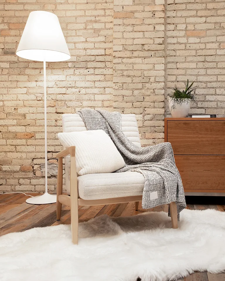 12 Moody Bedding Ideas That Make a Bedroom Feel Rich, Layered, and Intentional 9 Chunky knit throw draped at the foot of a dark bed
