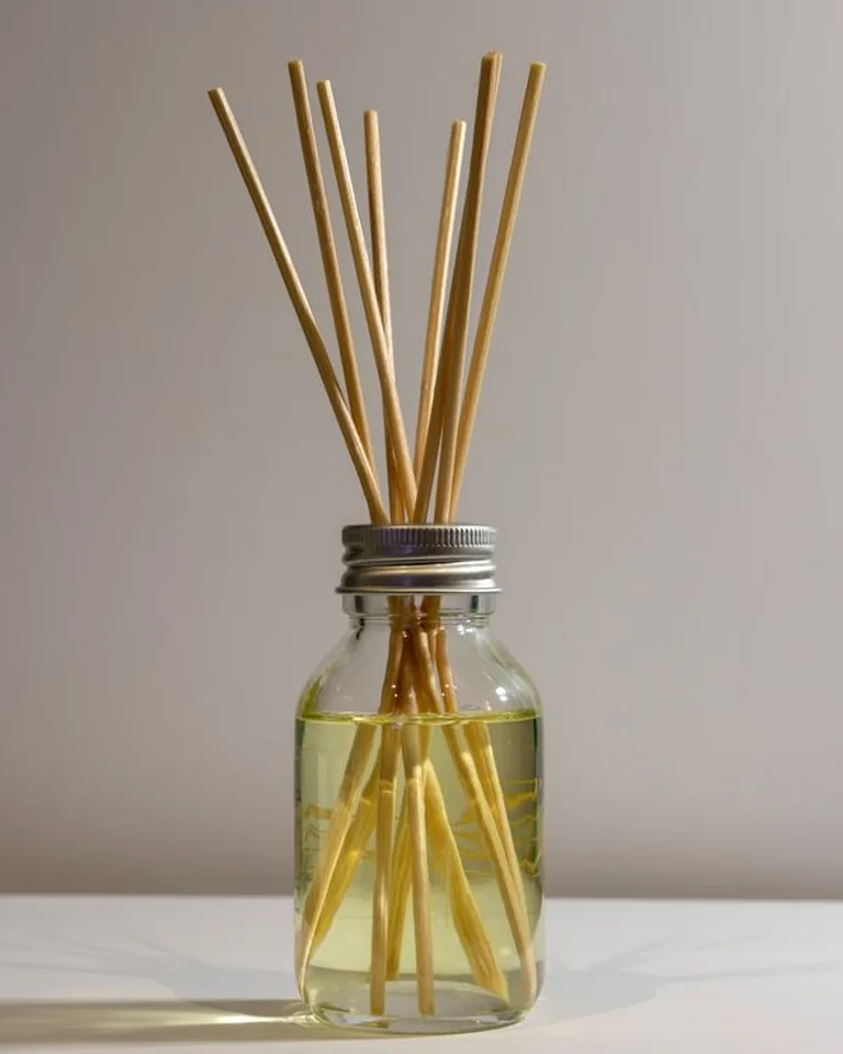 How to Make Your Home Smell Amazing Without Air Fresheners (11 Natural Ways) 13 Reed diffuser with rattan sticks in a glass jar on a side table
