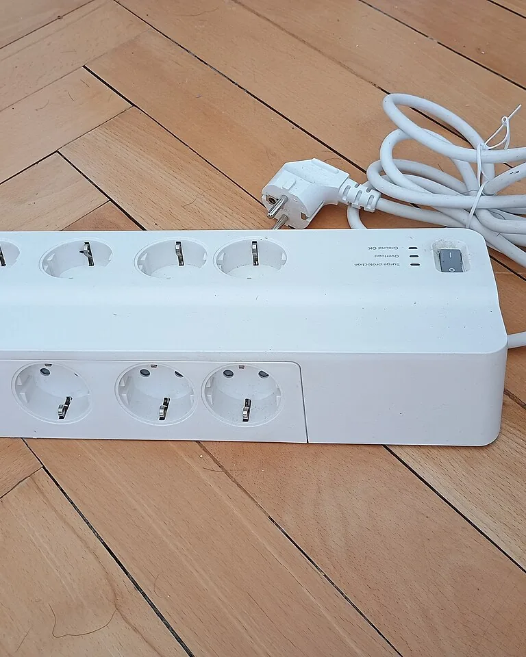 Neat power strip mounted behind a desk with routed cables