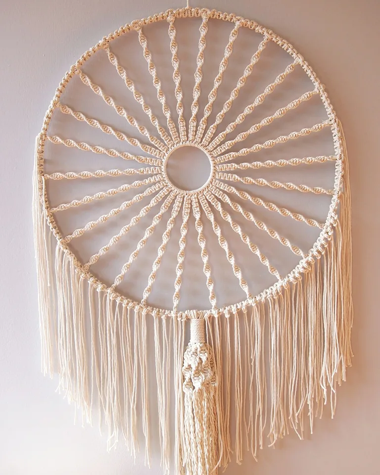 Handmade macrame wall hanging with beads in front of a window