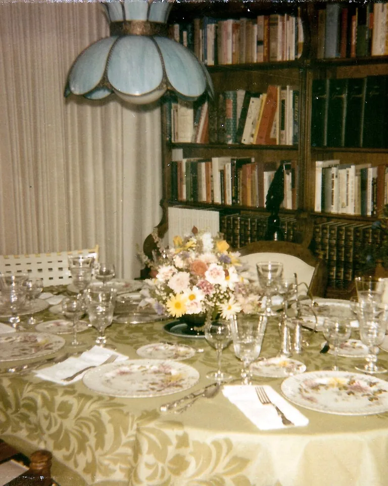 Small Thanksgiving table set with pumpkins, candles, and autumn napkins in warm light